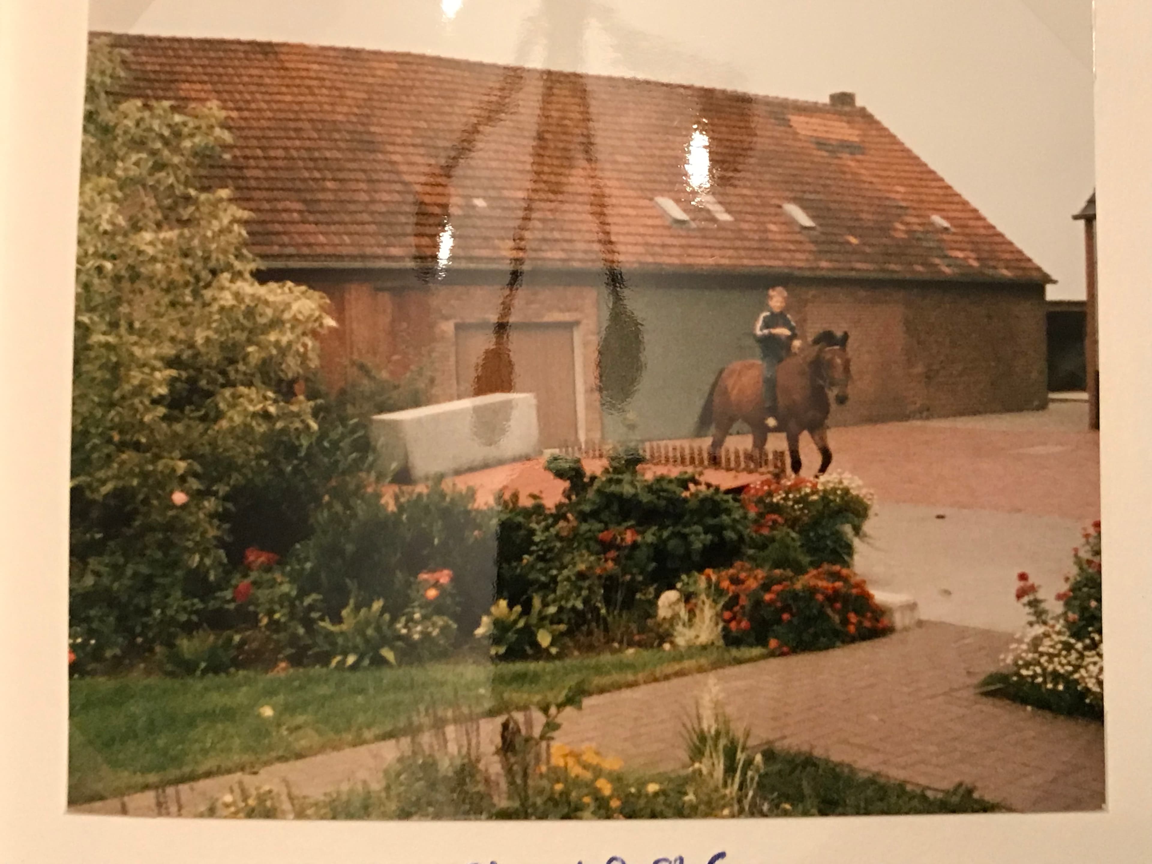 Der kleine Winkel reitet an den Hofgebäuden der Familie vorbei